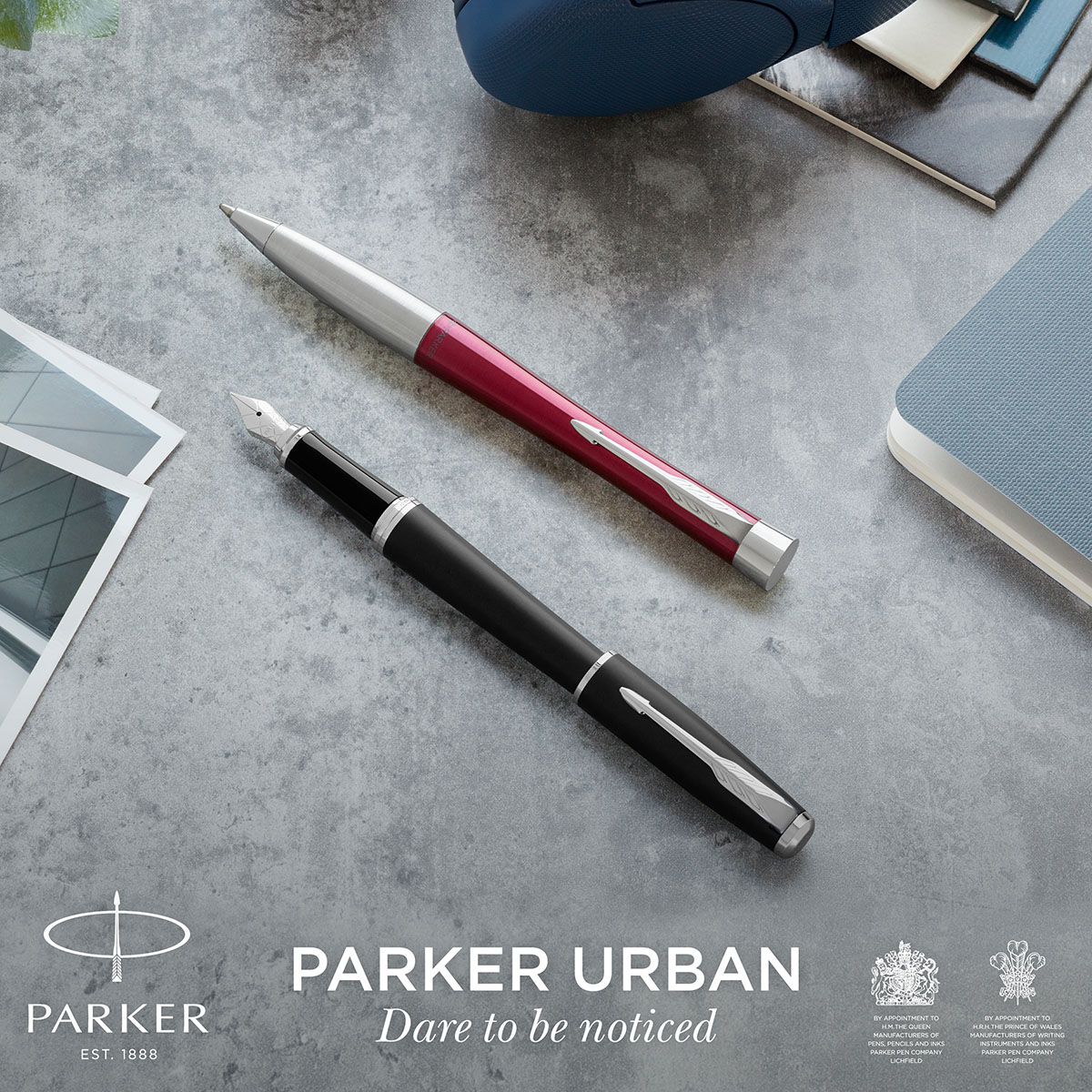 Długopis Parker Urban Magenta CT i czarne pióro wieczne Parker Urban CT na tle nowoczesnej aranżacji z logo Parker